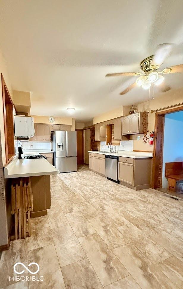 10946 Maze Rd, Indianapolis, IN 46259 - kitchen featuring appliances with stainless steel finishes, light countertops, ceiling fan, and a peninsula