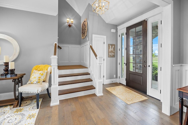 629 Perry Ln, West Lafayette, IN 47906 - entrance foyer with a chandelier, wood finished floors, wainscoting, stairs, and a decorative wall