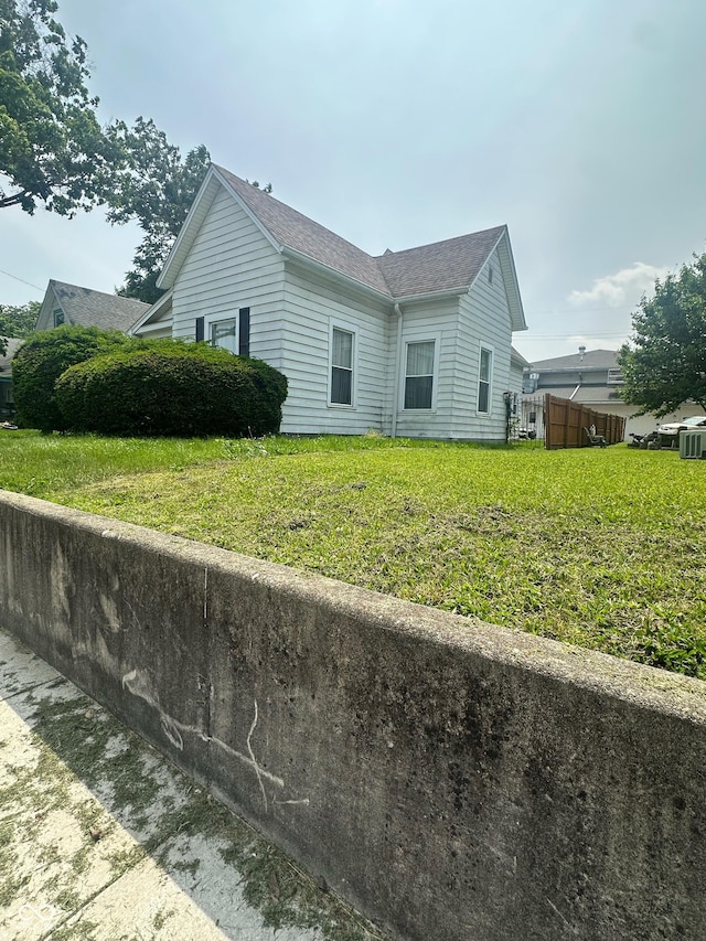 803 W 12th St, Anderson, IN 46016 - view of side of home featuring a shingled roof and a yard