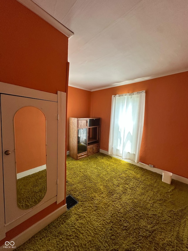 803 W 12th St, Anderson, IN 46016 - unfurnished living room with carpet floors, crown molding, and baseboards