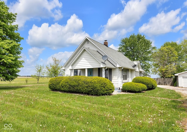 view of front of home featuring a chimney, a shingled roof, and a garage