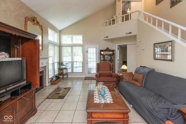 living room featuring a fireplace, light tile patterned floors, and high vaulted ceiling