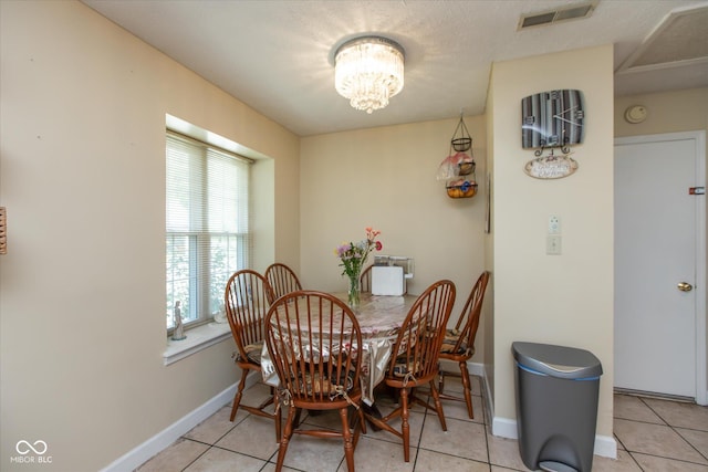dining space with a chandelier, baseboards, and light tile patterned floors