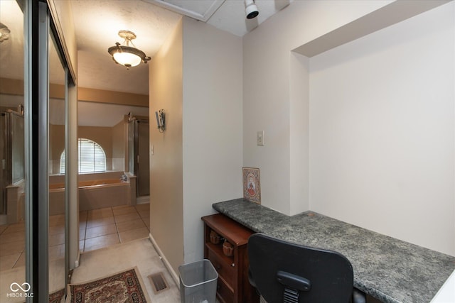 hallway with light tile patterned floors and a desk