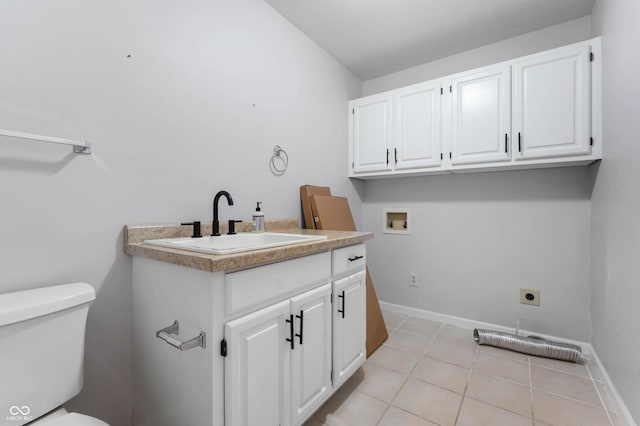 washroom with a sink, electric dryer hookup, light tile patterned floors, and baseboards