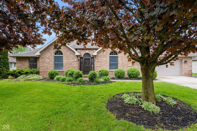 view of front of property with a front lawn, concrete driveway, brick siding, and a shingled roof