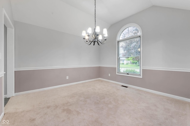 empty room with lofted ceiling, a chandelier, carpet, and baseboards