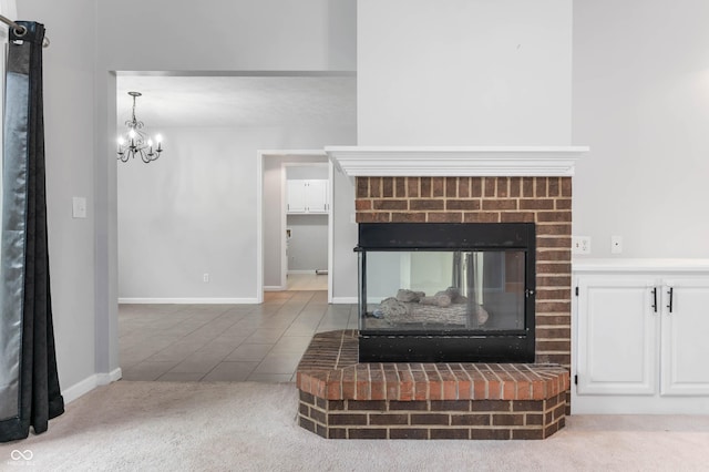 detailed view of a chandelier, carpet, baseboards, and a brick fireplace
