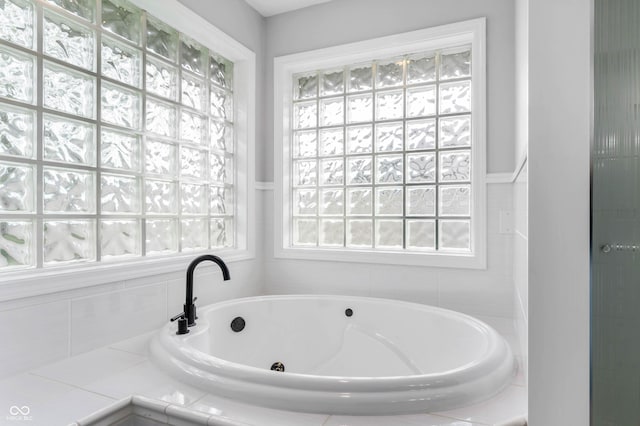 full bath featuring a garden tub and plenty of natural light