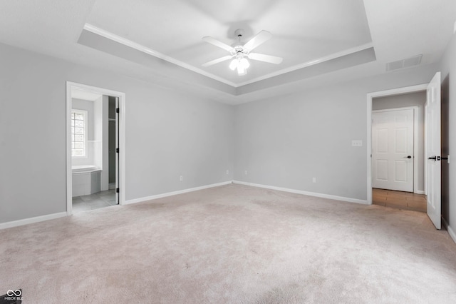unfurnished bedroom featuring a raised ceiling, carpet flooring, ornamental molding, and baseboards