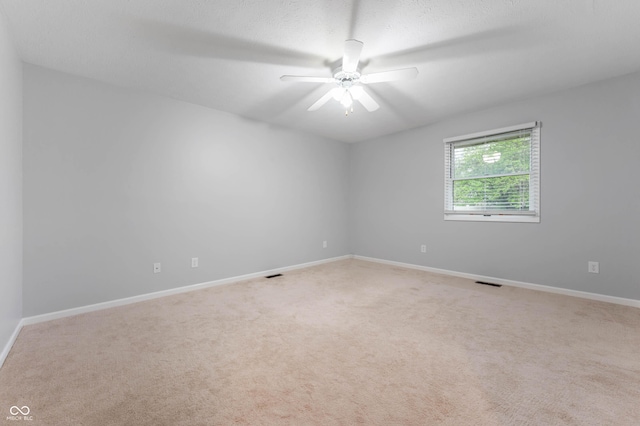 carpeted empty room featuring baseboards and ceiling fan