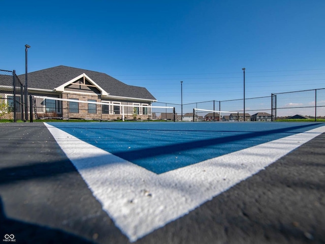 view of pool with fence and a tennis court