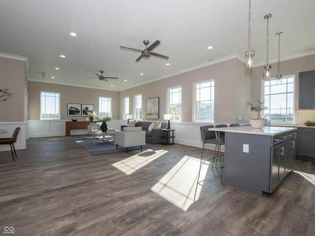 kitchen with crown molding, light countertops, ceiling fan, recessed lighting, and a center island