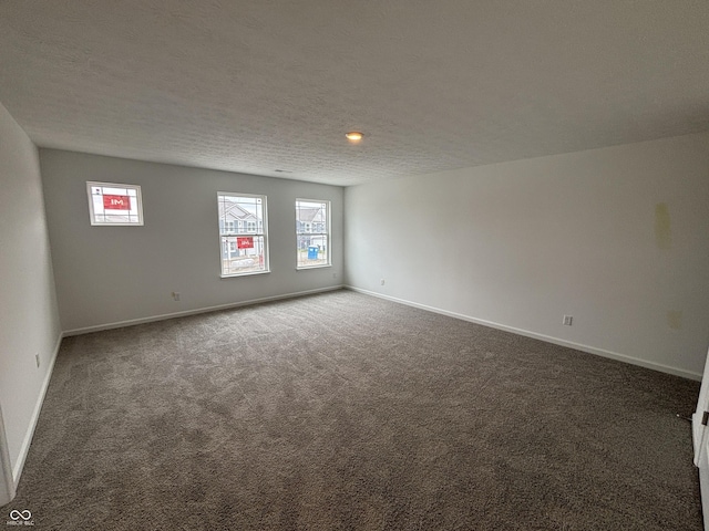carpeted spare room with baseboards, plenty of natural light, and a textured ceiling