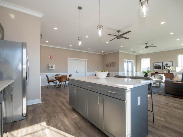kitchen featuring gray cabinetry, freestanding refrigerator, a kitchen breakfast bar, open floor plan, and light countertops