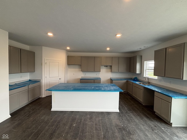 kitchen with a kitchen island, a sink, dark wood finished floors, gray cabinets, and recessed lighting