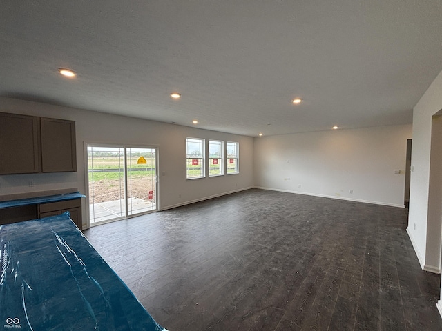 unfurnished living room with dark wood-style flooring, recessed lighting, and baseboards