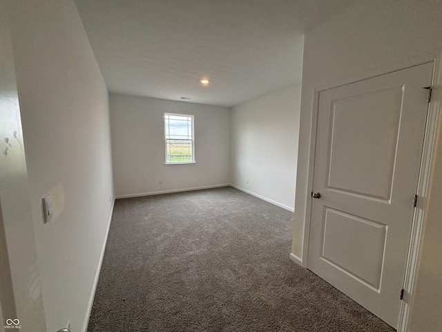 carpeted empty room featuring baseboards