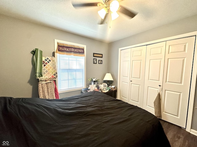 bedroom featuring a closet, ceiling fan, dark wood finished floors, and a textured ceiling