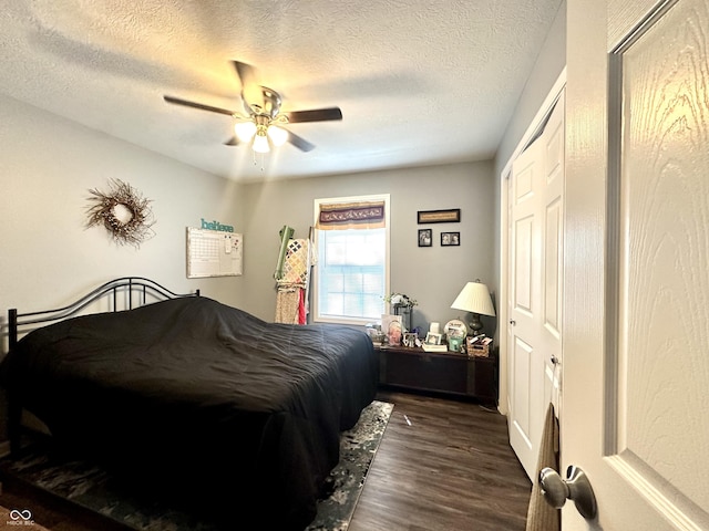 bedroom with dark wood-style floors, a textured ceiling, and a ceiling fan