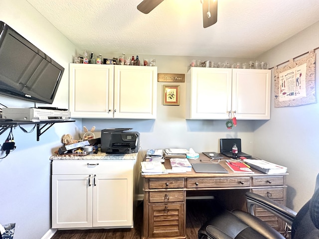 office area with ceiling fan, dark wood-style flooring, and a textured ceiling