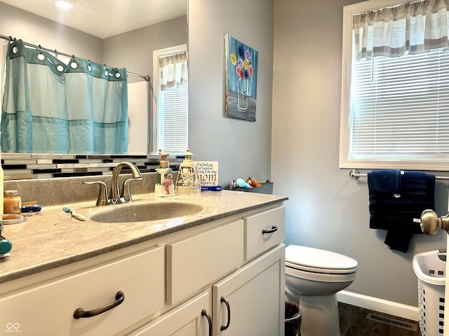 bathroom featuring baseboards, vanity, toilet, wood finished floors, and curtained shower
