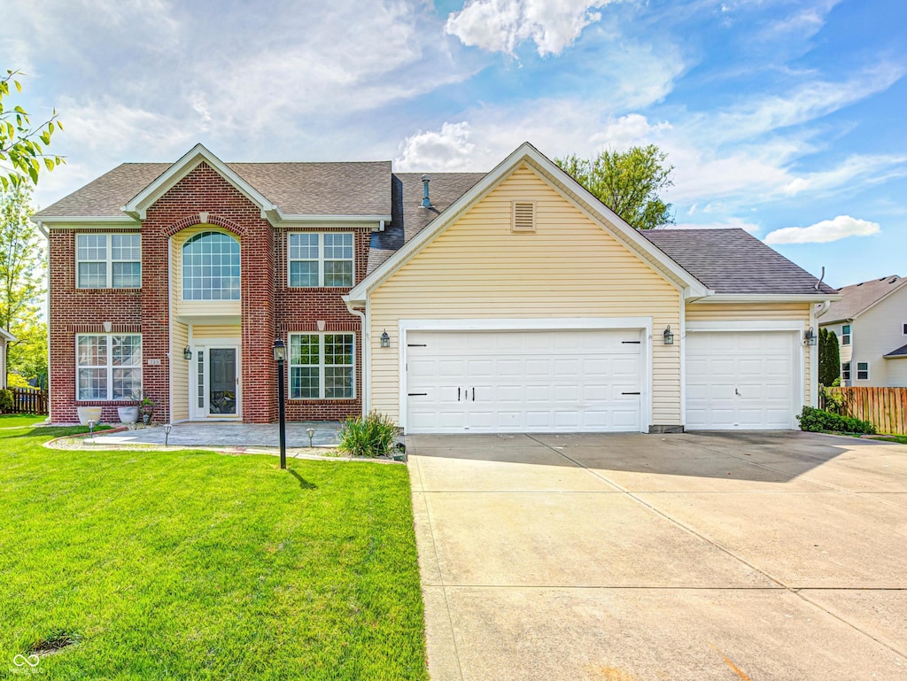 colonial home featuring concrete driveway, an attached garage, roof with shingles, and brick siding