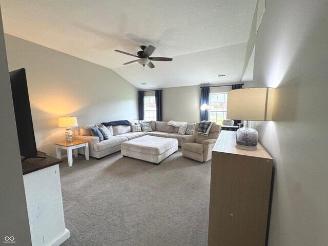 carpeted living area with ceiling fan and lofted ceiling