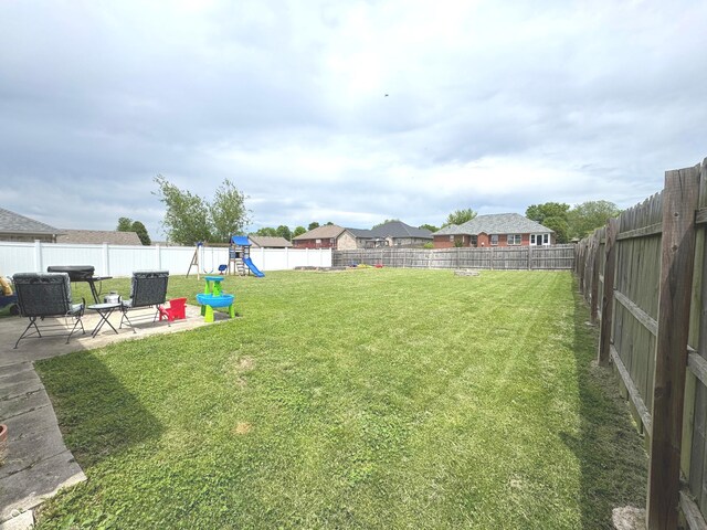 view of yard featuring a playground and a patio