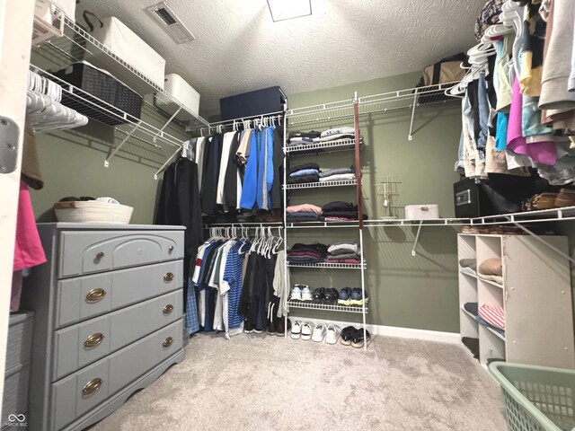 walk in closet with carpet floors