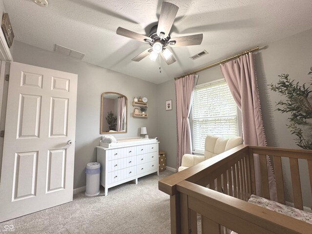 carpeted bedroom featuring ceiling fan, a textured ceiling, and baseboards