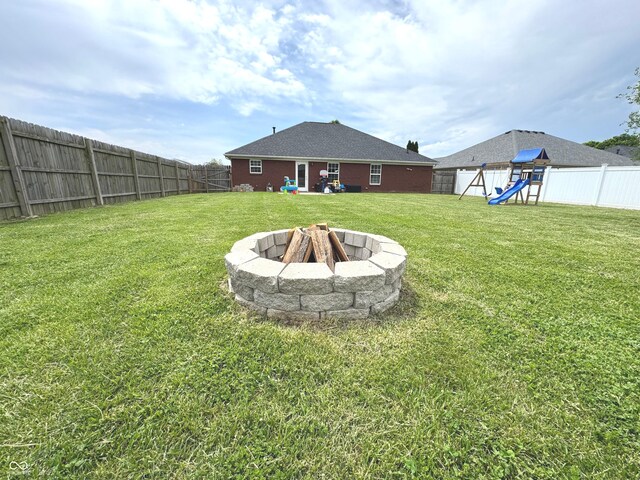 view of yard featuring a playground and a fire pit