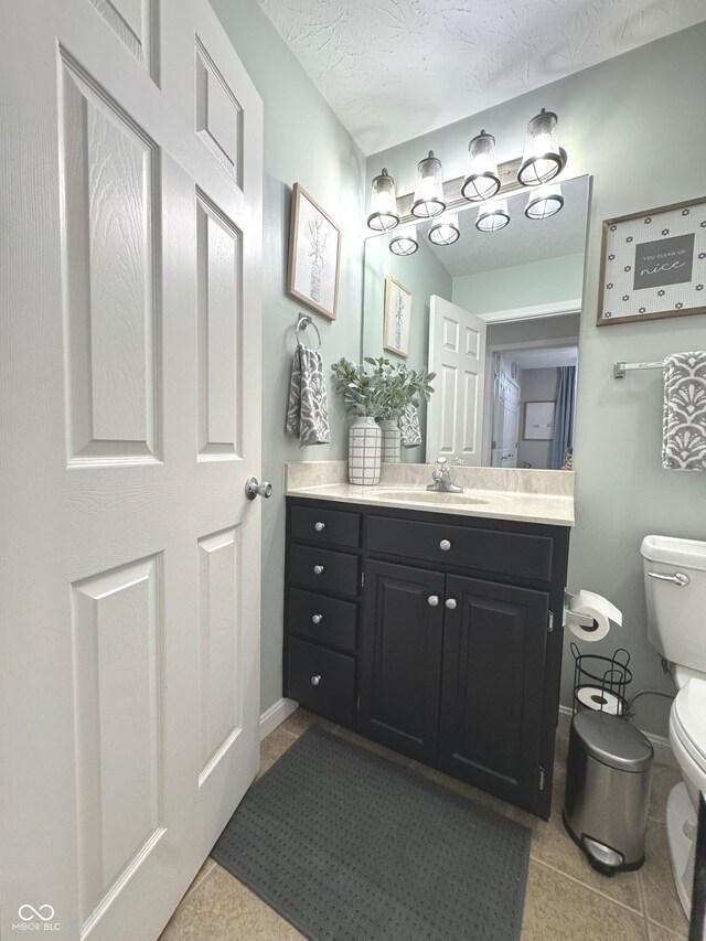 bathroom featuring toilet, vanity, and tile patterned floors