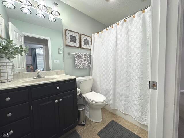 bathroom with toilet, vanity, a shower with curtain, and tile patterned flooring