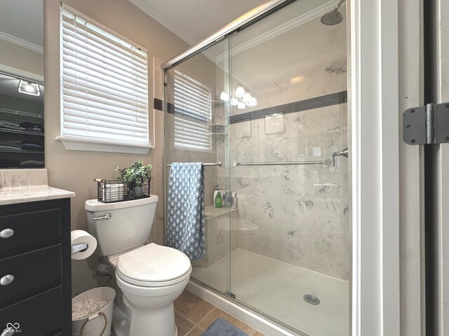 bathroom featuring crown molding, a shower stall, toilet, vanity, and tile patterned floors