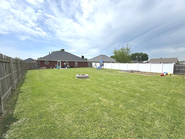 view of yard with a playground and a fire pit