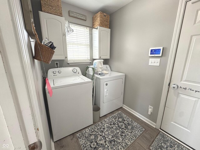 washroom with washing machine and clothes dryer, baseboards, and dark wood-style flooring