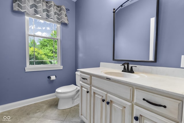 bathroom featuring baseboards, toilet, vanity, and tile patterned flooring