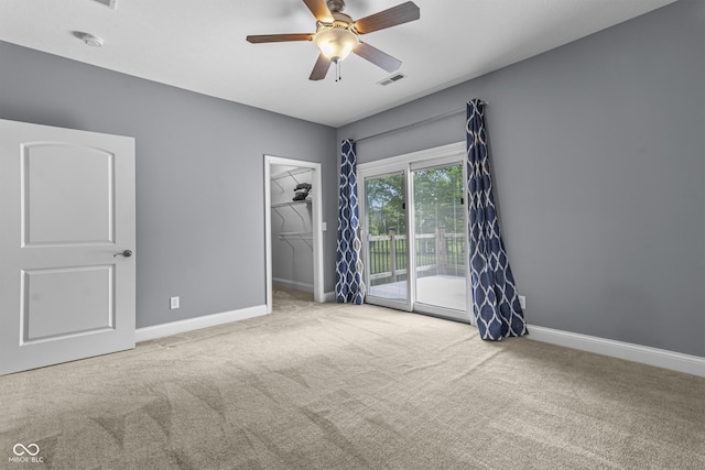 carpeted spare room featuring a ceiling fan, baseboards, and a smoke detector
