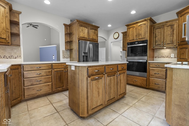 kitchen with open shelves, stainless steel appliances, arched walkways, backsplash, and recessed lighting