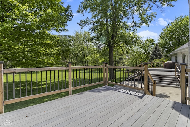 wooden deck with a lawn and view of wooded area