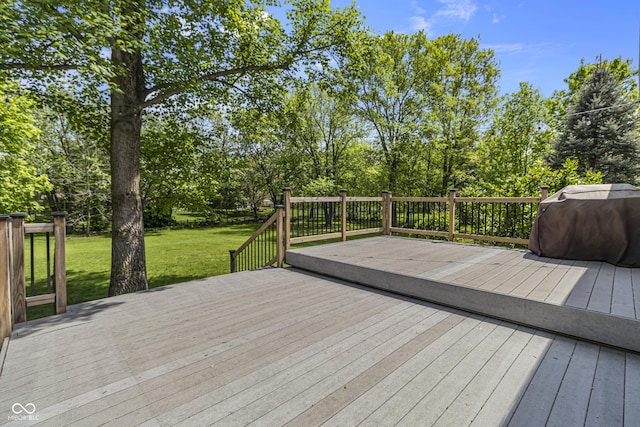 deck featuring a lawn and view of wooded area