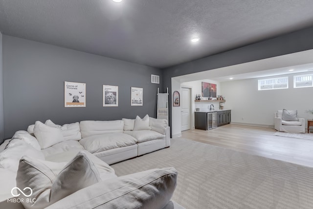 17346 Newton Main St, Westfield, IN 46074 - living area with wet bar, recessed lighting, light wood finished floors, baseboards, and a textured ceiling