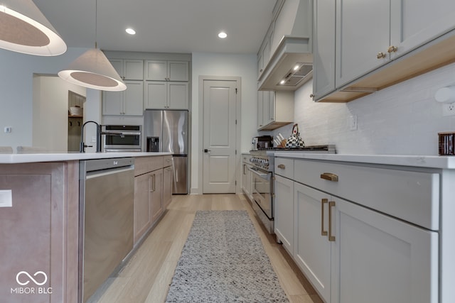 17346 Newton Main St, Westfield, IN 46074 - kitchen with stainless steel appliances, custom exhaust hood, light wood-style flooring, backsplash, and gray cabinetry
