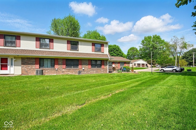 view of front facade with a front yard and brick siding