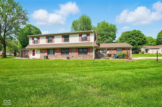 view of front facade featuring a front lawn, central AC unit, and brick siding