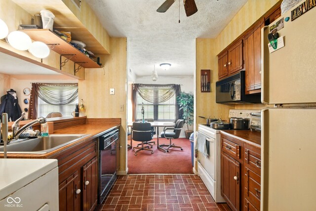 kitchen with black appliances, a sink, brick patterned floors, a ceiling fan, and dark countertops