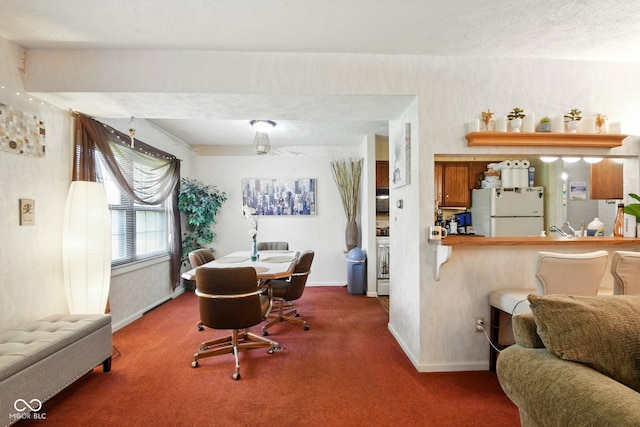 dining space featuring carpet flooring and baseboards