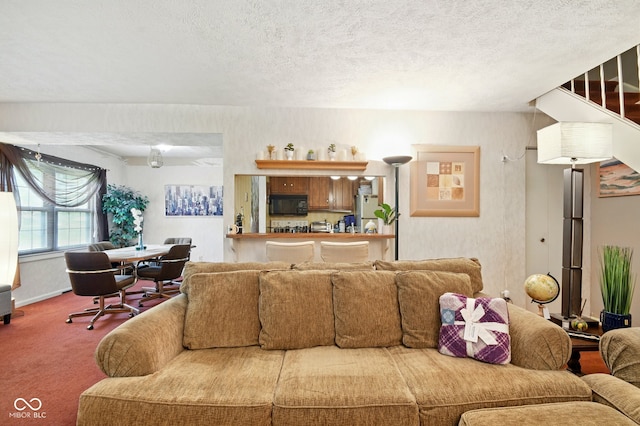 living room featuring carpet floors and a textured ceiling