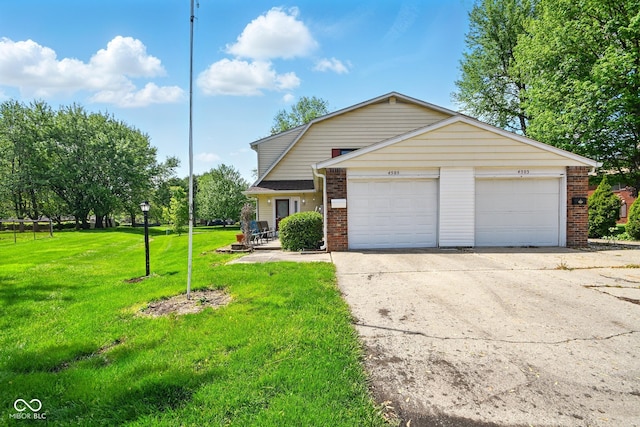view of front of house with brick siding, driveway, an attached garage, and a front lawn